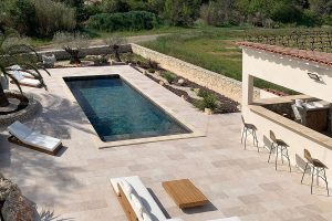 Terrace with swimming pool tiled with the Tiber collection, travertine look